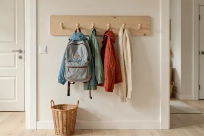 Porte-manteaux moderne pour enfants fixé au mur avec crochets arrondis sécurisés et vêtements colorés dans une entrée style scandinave