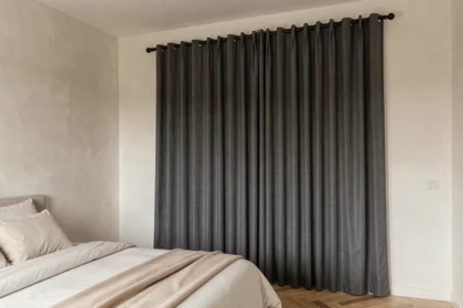Rideau occultant en lin gris anthracite dans une chambre moderne au parquet chêne clair